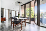 Dining area with dining table beside floor-to-ceiling balcony doors.