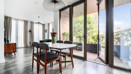 Dining area with dining table beside floor-to-ceiling balcony doors.