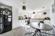 Kitchen and dining area with table, chairs, fitted units and appliances.