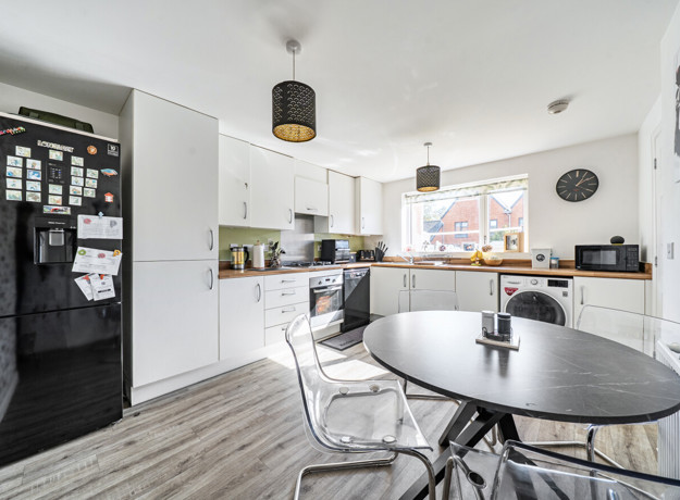Kitchen and dining area with table, chairs, fitted units and appliances.