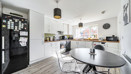 Kitchen and dining area with table, chairs, fitted units and appliances.