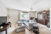 Living room with sofa, cabinet, TV and window with curtains.