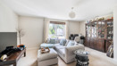 Living room with sofa, cabinet, TV and window with curtains.