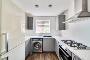 Kitchen with fitted units, gas hob and washing machine.