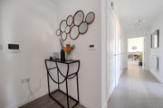 Entrance hallway with console table, wall mirror and doorway.