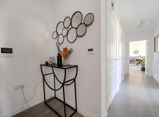 Entrance hallway with console table, wall mirror and doorway.