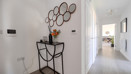 Entrance hallway with console table, wall mirror and doorway.