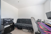 Home office with desk, computer monitors and storage units.