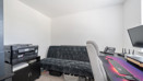 Home office with desk, computer monitors and storage units.